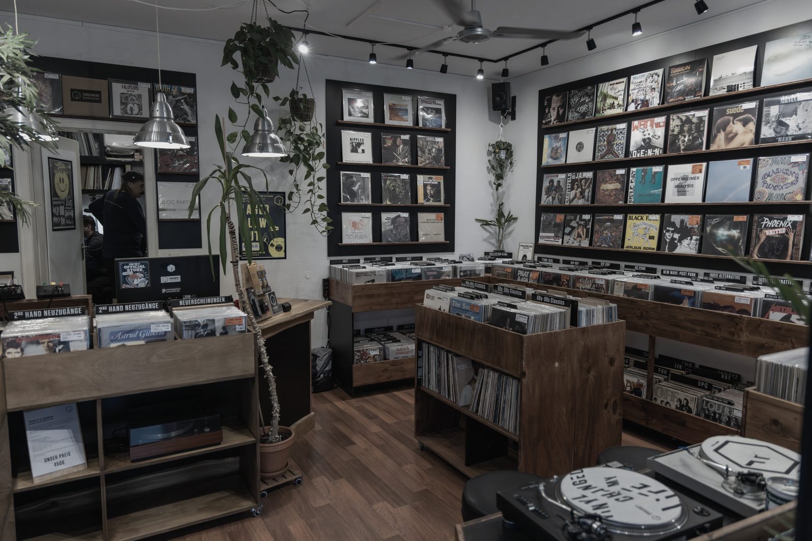 Der Verkaufsraum von FUNDAMENT Schallplatten: Plattenkisten, Regalwand mit Covern und Pflanzen.