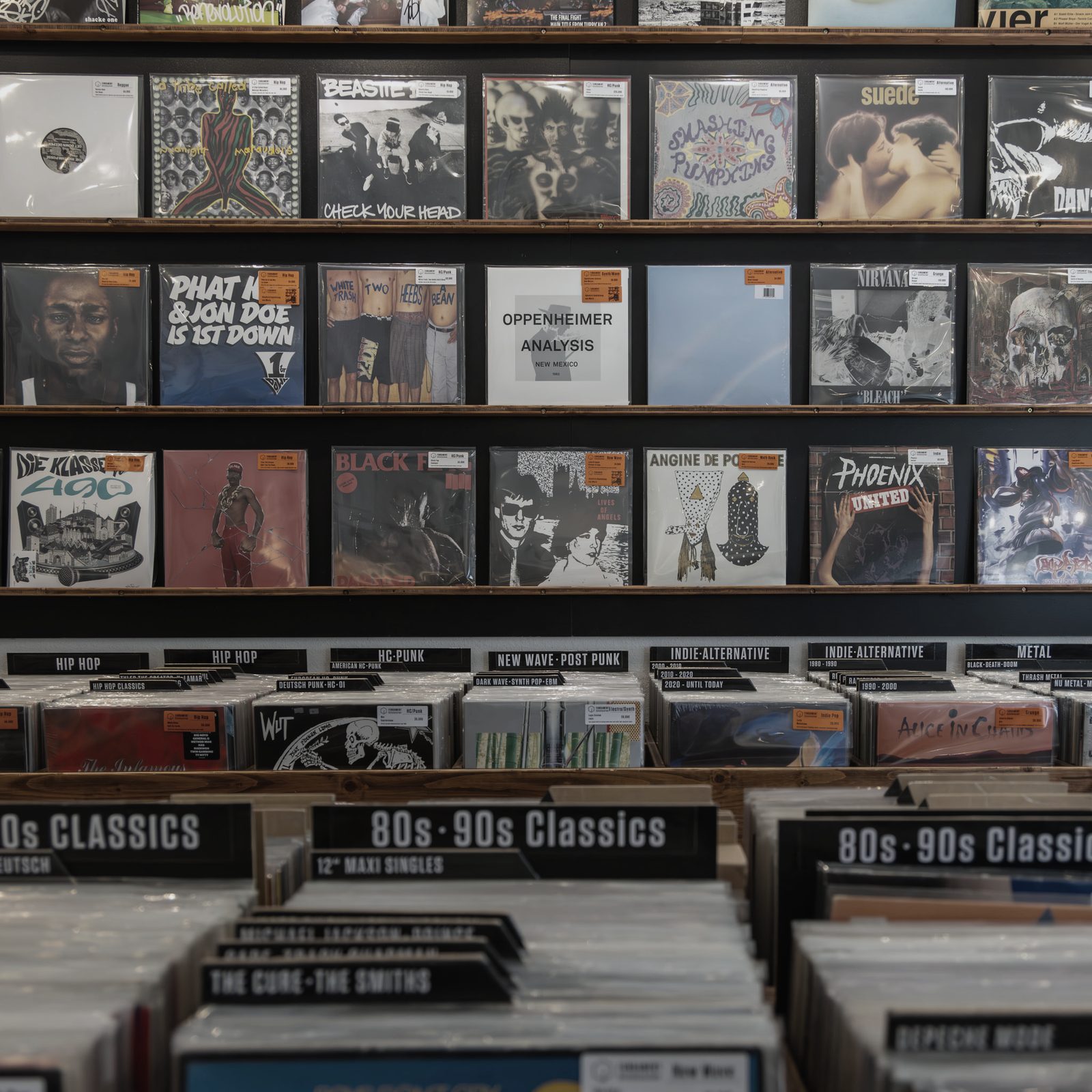 Regalwand mit Schallplatten, nach Genres beschriftet, darunter die Plattenkisten.
