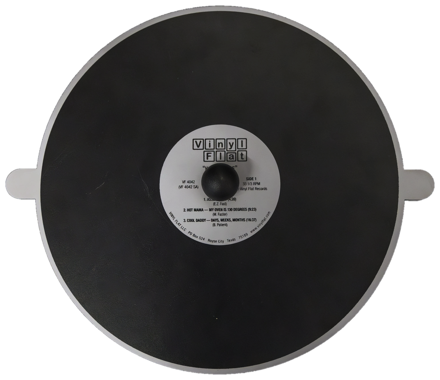 Der Vinyl Flat: runde Heizplatte mit zwei Griffen, in der Mitte das Etikett.